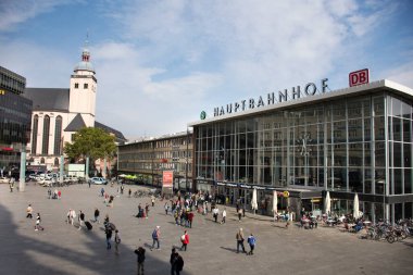 11 Eylül 2017 'de Almanya' nın Köln kentinde St. Ursula Köln Bazilikası ile Kolne Merkez Hauptbahnhof tren istasyonunun önünde yürüyen Alman ve yabancı gezginler