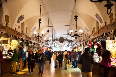 Polonyalı ya da Polonyalı insanlar ve yabancı gezginler 20 Eylül 2019 'da Polonya' nın Lesser kentindeki Stare Miasto 'daki Krakow Eski Şehir Meydanı' ndaki Rynek Parlak Pazarı 'ndaki kumaş dükkanını ziyaret edip alışveriş yapıyorlar.
