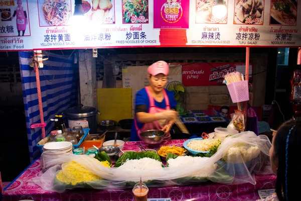 タイ人がタイ料理を作って販売する 外国人旅行者のためのタイ料理2020年2月28日の夜 タイのメーホンソンでパイ市の谷の丘で地元のストリートマーケットで購入し 食べる — ストック写真