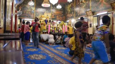 Taylandlılar ve yabancı gezginler, 12 Temmuz 2020 'de Tayland Samut Prakan' da Bang Phli Yai 'deki Wat Bang Phli Yai Tapınağı' nda dua ve ayin tanrısı Buda heykeline saygı duyarlar.