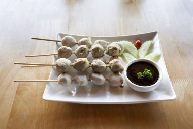 Et topu, sığır eti, domuz eti, tavuk ve seramik tabakta kızartılmış ve ızgara. Yanında salatalık sosu, sebze ve baharatlı tatlı sos var. Nonthaburi, Tayland 'daki kafe restoranında.