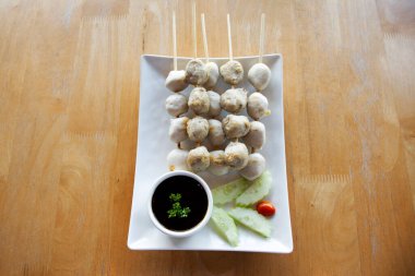 Et topu, sığır eti, domuz eti, tavuk ve seramik tabakta kızartılmış ve ızgara. Yanında salatalık sosu, sebze ve baharatlı tatlı sos var. Nonthaburi, Tayland 'daki kafe restoranında.