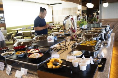 Geleneksel Japon yemek gurmesi hattı ve yemek odasında Amerikan açık büfesi. Misafirler için yemek servisi. 22 Temmuz 2025 'te Tokyo, Japonya' da lezzetli içecekler yiyin.