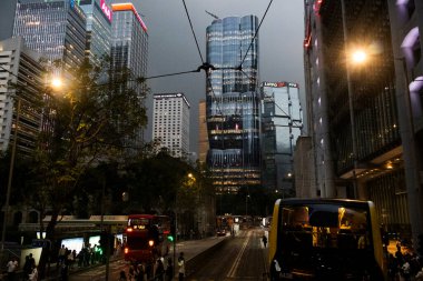 26 Nisan 2025 'te Hong Kong, Çin' de trafik yolunda gece vakti yürüyen Hong Kong şehrinin gökdelen şehir manzaralı evini, gece hayatını ve yerel Çin yaşam tarzını izleyin.