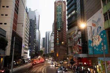 26 Nisan 2025 'te Hong Kong, Çin' de trafik yolunda gece vakti yürüyen Hong Kong şehrinin gökdelen şehir manzaralı evini, gece hayatını ve yerel Çin yaşam tarzını izleyin.