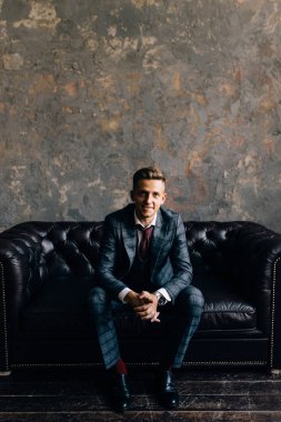 Bir stüdyoda bir moda çekimi için poz yakışıklı delikanlı. Moda bir yaşam tarzı olarak. Smokin bir kanepede oturan modeli. Başarılı moda iş adamı. İş reklam bak 