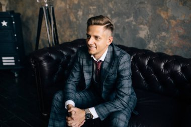 Bir stüdyoda bir moda çekimi için poz yakışıklı delikanlı. Moda bir yaşam tarzı olarak. Smokin bir kanepede oturan modeli. Başarılı moda iş adamı. İş reklam bak 