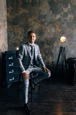 Kendine güvenen genç adam şık elbiseli kameraya bakıyor