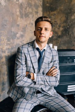 Mavi elbiseli bir adam bir sandalyede oturuyor