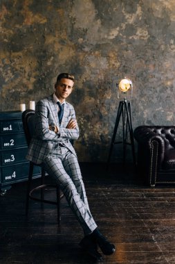 Mavi elbiseli bir adam bir sandalyede oturuyor