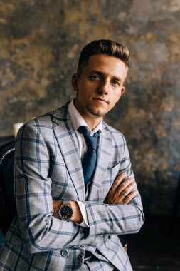 Mavi elbiseli bir adam bir sandalyede oturuyor