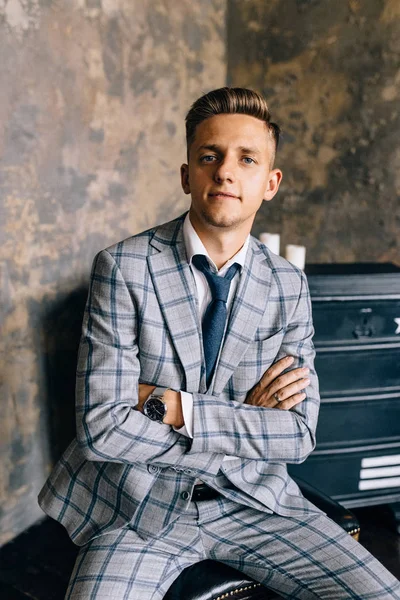 Mavi elbiseli bir adam bir sandalyede oturuyor