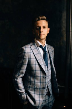 Adam bir takım elbise poz. Yanal sert ışık.