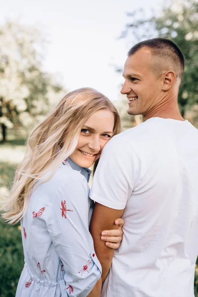 Portrét šťastná mladá usmívající se pár v lásce přes kvetoucí Ružina — Stock fotografie