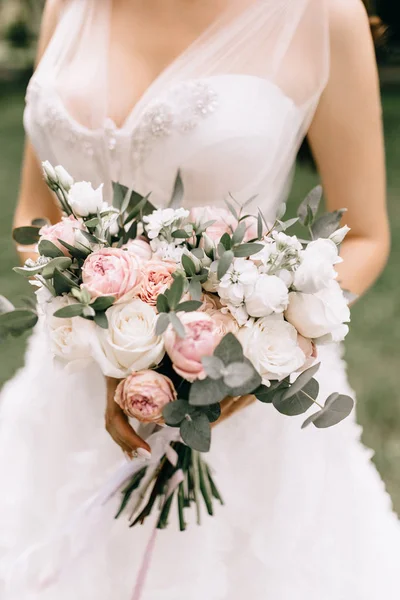 Ramo de novia en las manos de las novias. Novia en el jardín —  Fotos de Stock