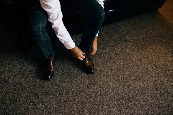 Un hombre elegante se pone zapatos negros, de cuero, formales. Atando zapatos — Foto de Stock