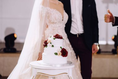 lezzetli düğün pastası ve çift arkasında duran yakın çekim görünümü, kırpılmış atış