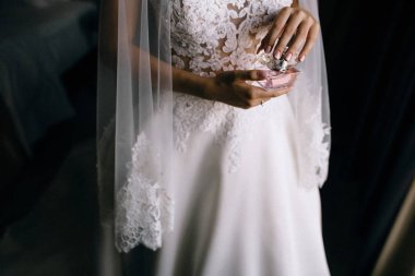 beyaz gelinlik ve peçe tutan parfüm şişesi genç gelinin kırpılmış çekim 