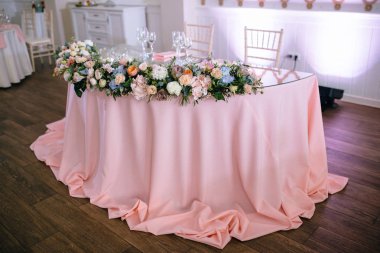 düğün resepsiyonda pembe masa örtüsü, boş gözlük ve çiçek süslemeleri ile masanın yüksek açı görünümü 