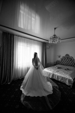 gelinlik ve peçe yatak odasında ayakta güzel genç gelinin arka görünümü, siyah beyaz fotoğraf  