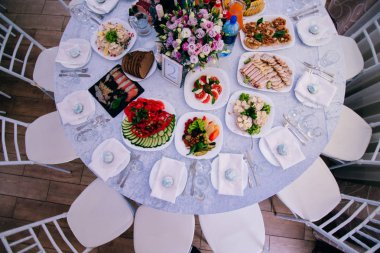 düğün resepsiyonunda vazoda lezzetli yemekler ve çiçekler ile masanın üst görünümü