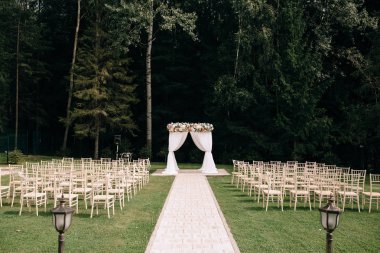 yeşil çim üzerinde çiçek ve boş sandalyeler ile güzel düğün kemer