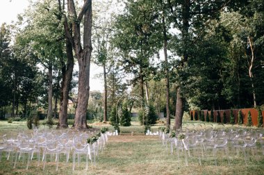 çiçek süslemeleri ve açık düğün töreni için hazır çiçekler ile düğün kemeri ile boş sandalyeler