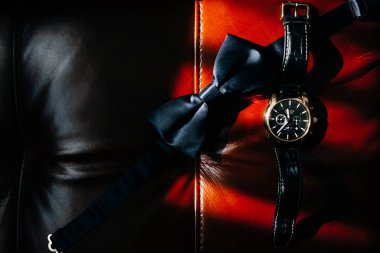 kırmızı ve siyah deri yüzeyde siyah papyon ve kol saati üst görünümü