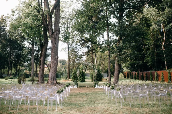 çiçek süslemeleri ve açık düğün töreni için hazır çiçekler ile düğün kemeri ile boş sandalyeler