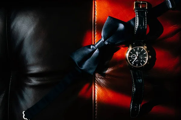 kırmızı ve siyah deri yüzeyde siyah papyon ve kol saati üst görünümü