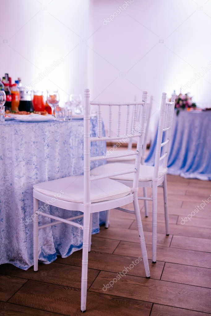 empty white chairs and served tables at wedding reception