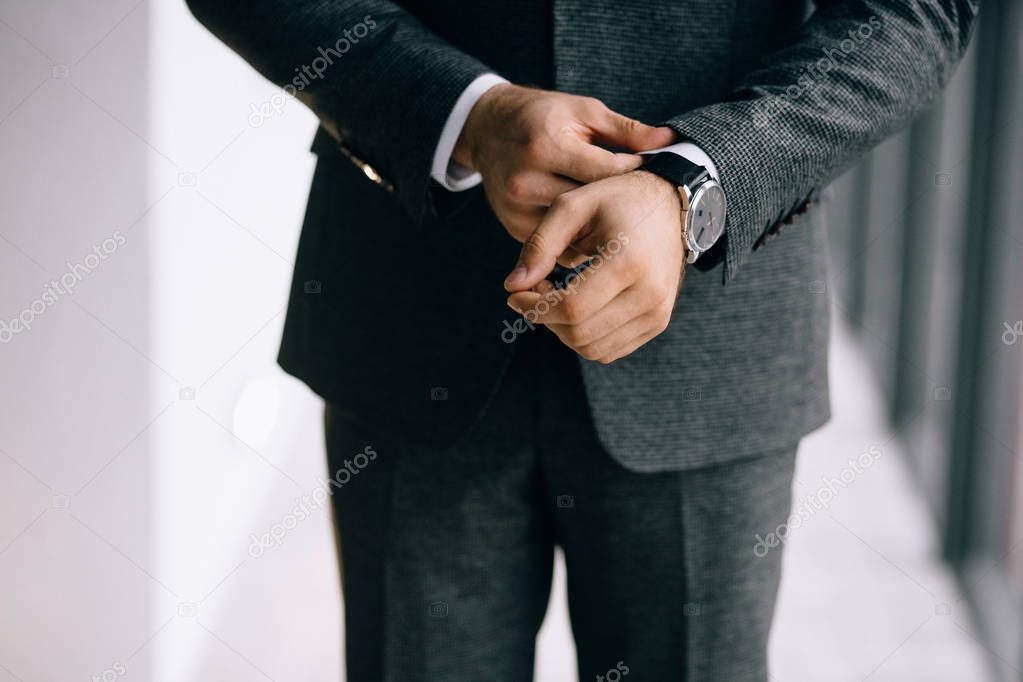 cropped shot of groom in suit wearing wrist watch