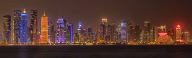 Doha, Katar geceleri gökyüzüne yükseliyor Arap körfezinde ışık yansıması ile