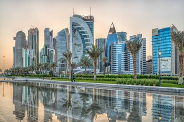 Doha, Qatar-March 15,2018: Doha, Qatar Skyline daylight view from Sheraton park with reflection in the water  clipart