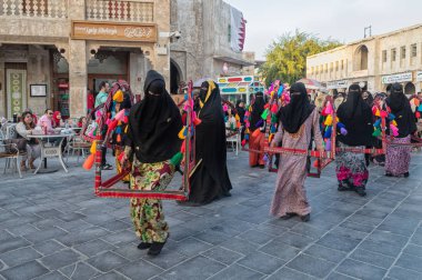 Doha, Katar-4 Ocak 2019: Souk Waqif gündüz görüşünde dans eden geleneksel Arap kadınları