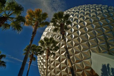 Orlando Florida,USA-December 15,2014:  view of the sphere Spaceship Earth attraction at Epcot in Walt Disney World with trees and clouds in sky. clipart