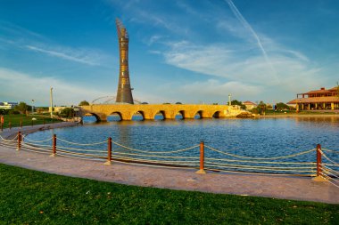 Aspire Parkı Doha Katar Gün Işığı manzaralı Fıskiyeli ve Arkaplanda El Feneri Doha Oteli Gökyüzünde bulutlarla