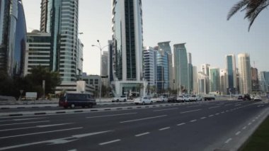 Doha, Katar-26 Haziran 2020: Doha Cor-niche Sheraton Parkı 'nda gün ışığında Batı Körfezi gökdelenleri ve caddelerindeki arabaları gösteriyor .
