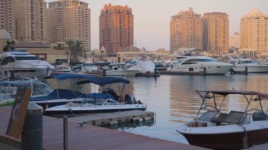 Porto Arabistan Marina 'daki Şatafatlı Yatlar, Arkaplanda ufuk çizgisi olan İnci Katar Günbatımı