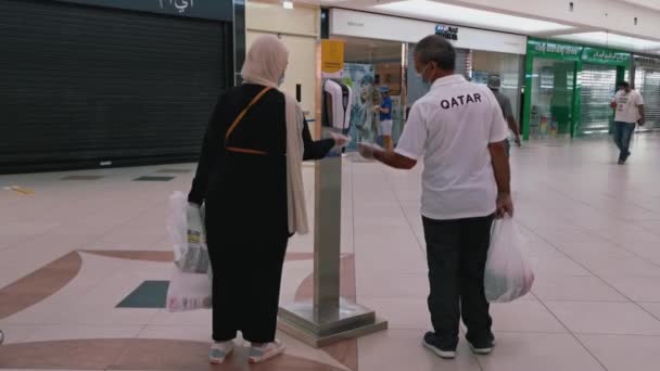 Чоловік Жінка Вуаллю Допомогою Автоматичного Очищувача Рук Центрі Магазину Доха — стокове відео