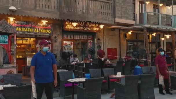 Souq Waqif ドーハ カタール 2020年7月23日 日没時のメインストリート人々が座って歩いている伝統的なコーヒーショップコロナウイルスパンデミック後にカタールが再開 — ストック動画
