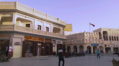 Souq Waqif Doha, Katar ana caddesi gün batımında eski polis karakolu ve Katar bayrağını gösteriyor.