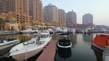 Porto Arabistan Marina in The Pearl Doha, Katar yaz çekimleri lüks yat ve botların arka planda konut binalarıyla limana yanaştığını gösteriyor.. 