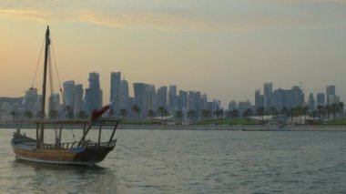İslam Sanatları Müzesi 'nden Doha ufuk çizgisi. Gün batımı. Arap körfezinde Katar bayrağı ve arka planda bulutlar görünüyor.