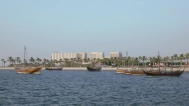 Doha, Katar 'ın günbatımı çekimleri Katar Körfezi' ndeki Katar bayrağıyla arka plandaki Katar liman otoritesini gösteriyor.
