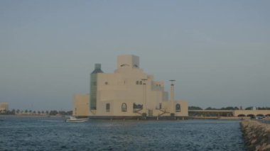 İslam Sanatları Müzesi Doha Katar dış gün batımı Doha Corniche 'den ön planda Arap körfezinde tekne ve arka planda ufuk çizgisi ile çekim