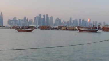 Doha corniche, Katar 'lı adamları, Katar bayraklarıyla birlikte Arap Körfezi' nde Doha silueti arkaplanının keyfini çıkarırken gösteriyor.