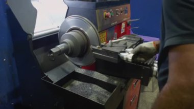 Koruyucu eldivenli bir araba tamircisi araba fren diskini cilalar. Araba servisi, araba tamiri.