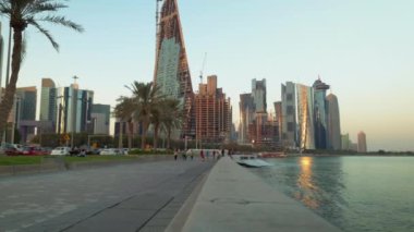 Doha Corniche öğleden sonra insanları yürürken, koşarken, Arap körfezinde Dhow ve Doha silueti arkaplanırken görüntüledi. 