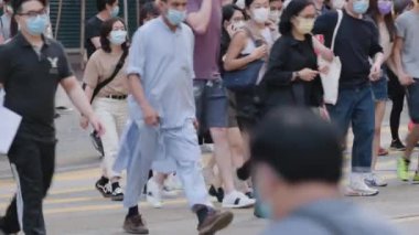 Hong Kong 'da tıbbi maske takan tanınmamış insanların yavaş hareket etmesi.. 